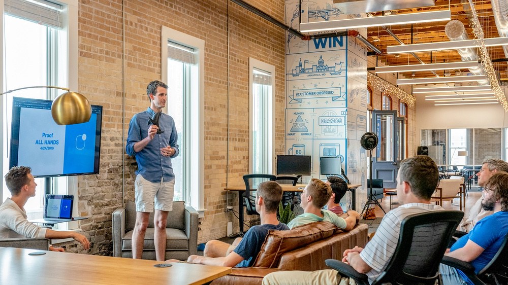 Presenter speaking to a seated team during an all-hands meeting