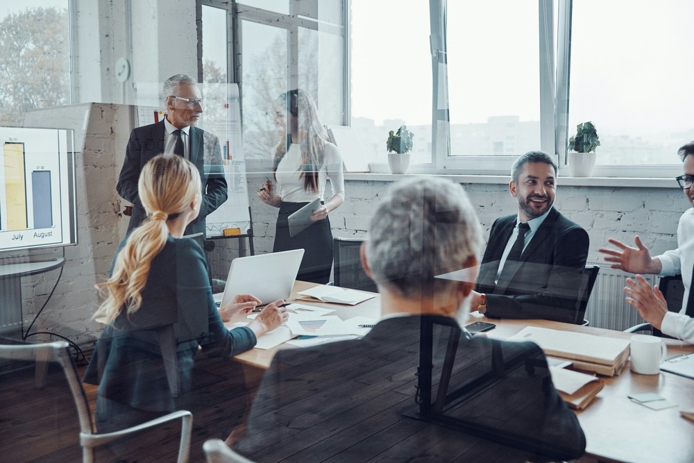 Executive team reviewing a chart in a glass-walled boardroom